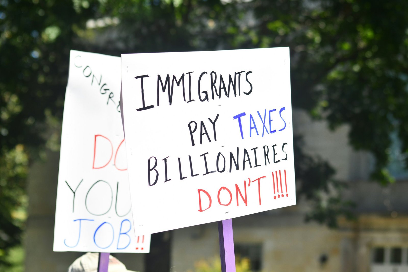 Protest signs about taxes and jobs