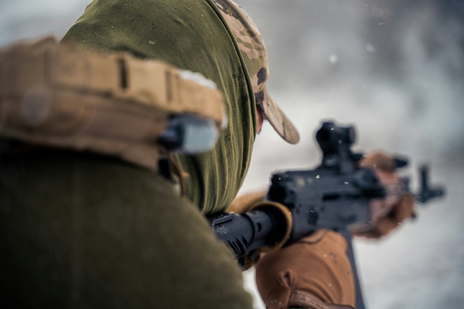 a man with a hat holding a rifle